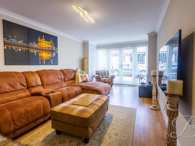 Time now to look at the bright and comfortable main living room. Two windows overlook the garden and a set of double doors lead outside.