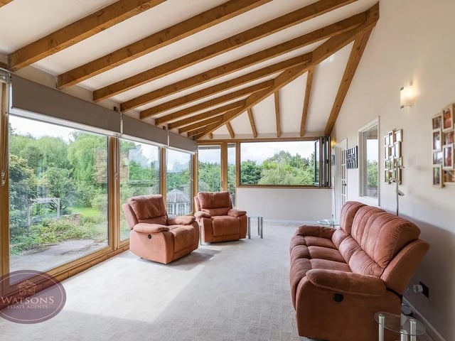 The light and airy garden room is surrounded by picture windows giving views over the gardens.