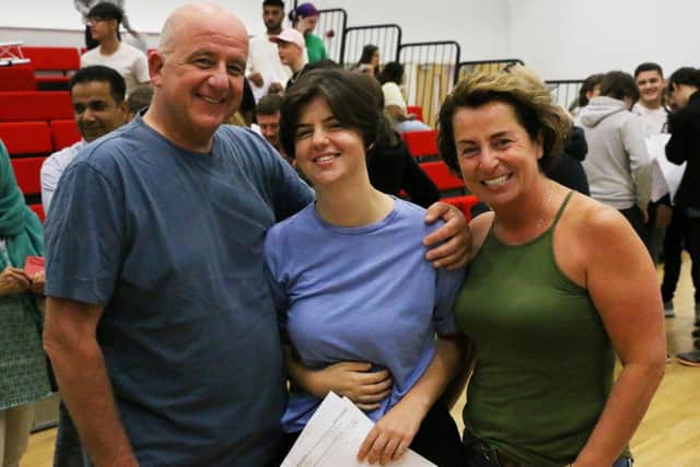 Lizzi Jackson (centre), who got a distinction* and nine eights, with her parents, Kristian Jackson and Linda Booth
