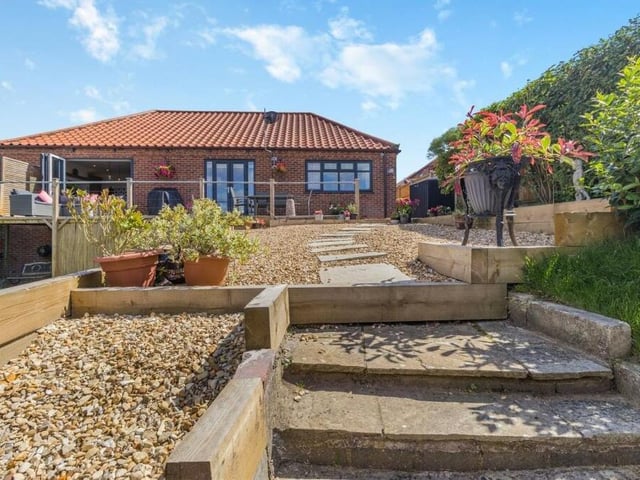 From the balcony-patio, a sandstone pathway leads to steps that take you down to the lower-level garden