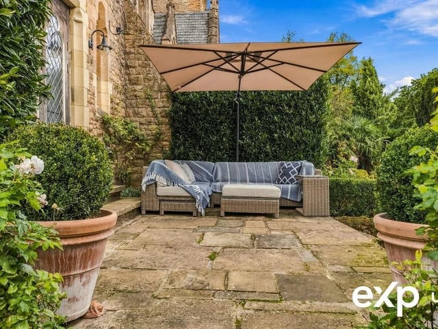 A paved patio seating area stretches across the rear and extends the living space