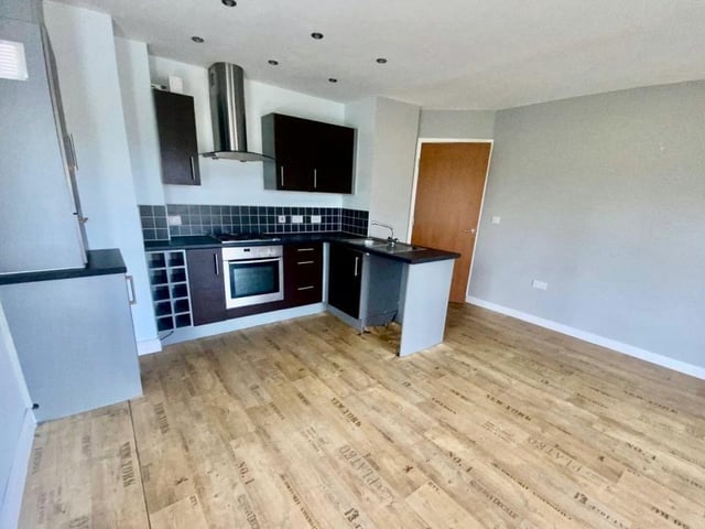This image gives a better view of the modern, fitted kitchen, which includes an integrated oven and hob. There is plenty of storage space too.