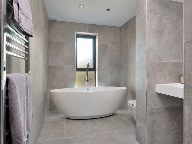 Having a beautifully appointed contemporary four piece suite bathroom comprising an oval shaped bathtub, separate walk-in tiled shower enclosure, wash hand basin and wall-hung WC.