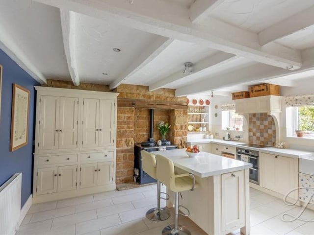 Into the kitchen now, where a characterful room comes complete with a range of traditional units and cabinets, plus a complementary work surface and Belfast sink. There are also built-in cupboards and a central island with breakfast bar.