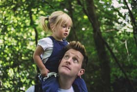 Dad walking with daughter on his shoulders through an RSPB nature reserve