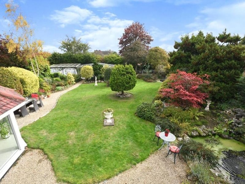 A bird's eye view of the delightful back garden, with its lawn, mature shrubs, trees, plants and hedges.
