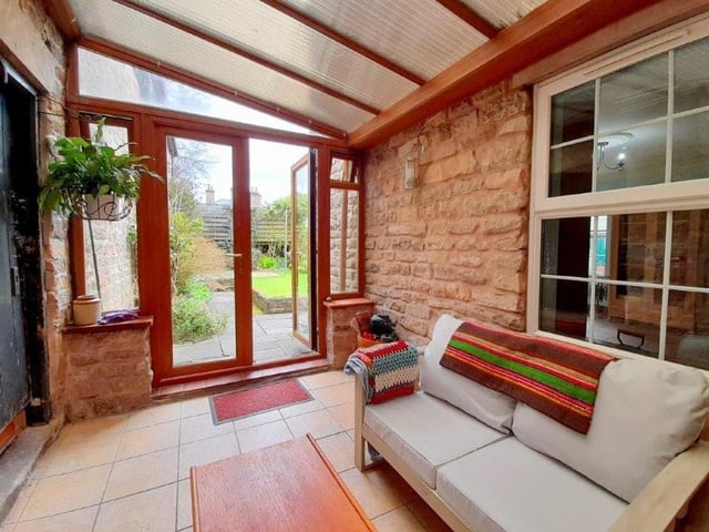 At the back of the cottage is this covered entrance with seating area. A lovely, unique feature.