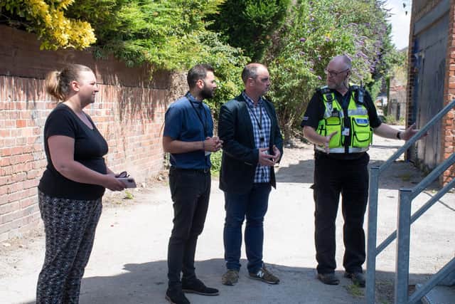 Richard Townsley, Ashfield District Council Community Protection Officer, Councillor David Hennigan, Antonio Taylor, the council's Community Protection Manager, and Councillor Samantha Deakin walking down the so-called Mucky Alley, next to Outram Street.