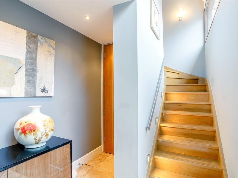 Entry to the south aspect leads into a bright entrance hall which is partially vaulted with a floor-to-ceiling feature window and a tiled floor