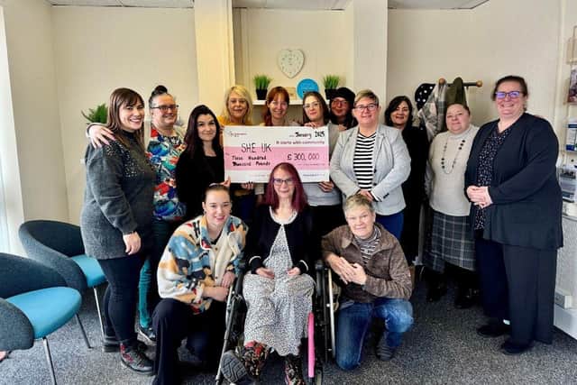 The S.H.E. UK Team receiving the cheque from the National Lottery Reaching Communities Fund.