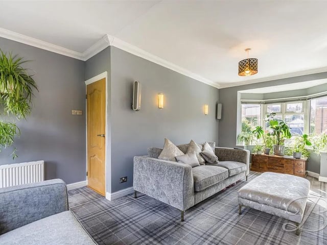 The living room is a spacious room with built in storage cupboards, triple aspect windows to the front, side and rear, along with an external door to the rear elevation.