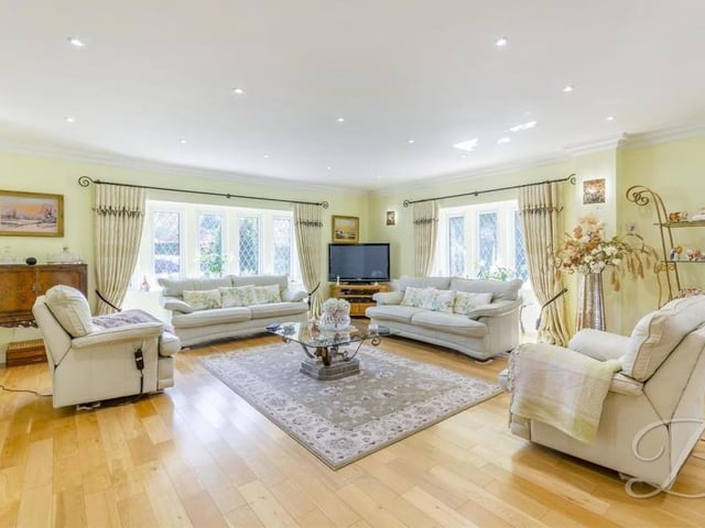 A second shot of the beautiful living room, with its solid oak flooring, coving to the ceiling and downlights. There are double-glazed bay windows to the front and side of the house.