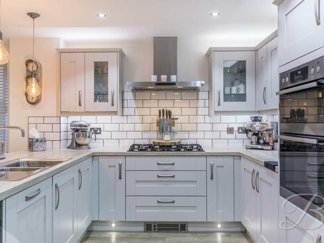 The kitchen is modern and attractive, comprising a superb range of matching cabinets and units, with work surfaces over, an inset sink and splashback tiles.