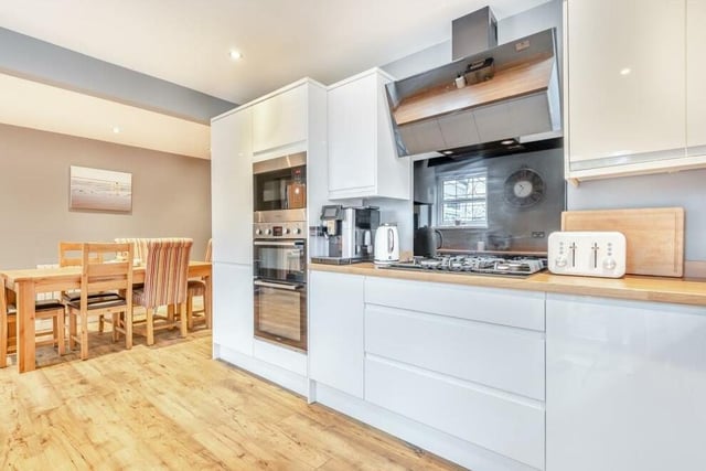 Integrated appliances within the kitchen/diner include a double oven, separate microwave above, a five-ring gas hob with contemporary touch-screen extractor hood above, and also a dishwasher.