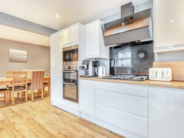 Integrated appliances within the kitchen/diner include a double oven, separate microwave above, a five-ring gas hob with contemporary touch-screen extractor hood above, and also a dishwasher.