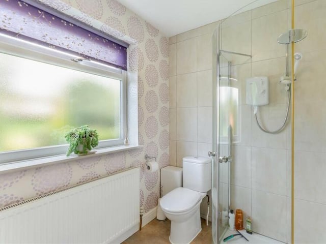 The downstairs toilet at the £649,950 Mansfield property doubles up as a shower room. A three-piece white suite comprises a tiled shower cubicle, with electric Triton shower, low-flush WC and vanity unit with inset wash hand basin and storage cupboard beneath.