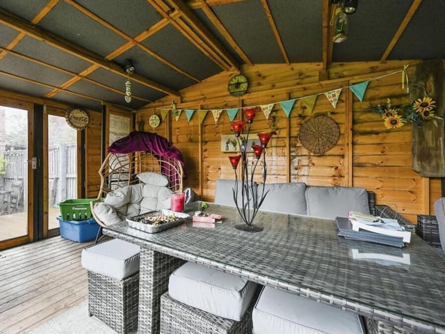 The highlight of the garden is this large, bespoke summer house, which has been turned into an attractive, homely spot for gatherings or parties.