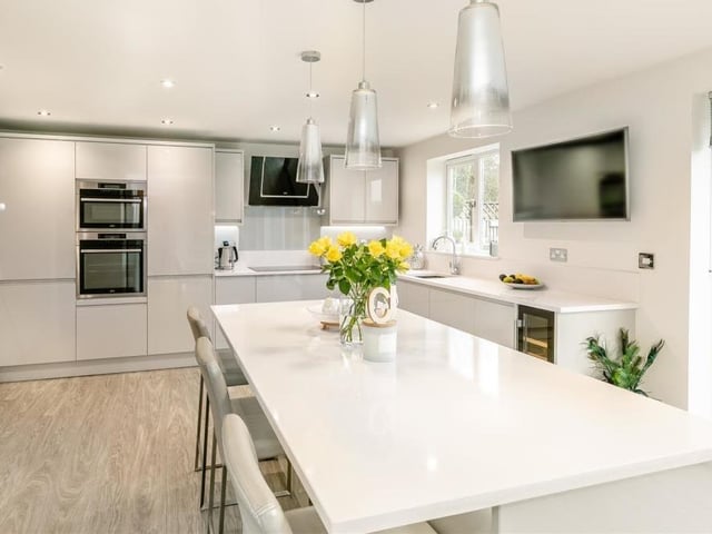The dining kitchen boasts a range of modern, high-gloss cabinets, comprising wall cupboards with under-lighting, base units and drawers, all complemented by quartz worktops. There are ten ceiling spotlights and a vinyl floor.
