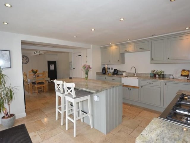 Next stop is the attractive kitchen, which has an integrated fridge and dishwasher, CDA range cooker with five-ring hob, centre island with granite worktop and a breakfast bar.