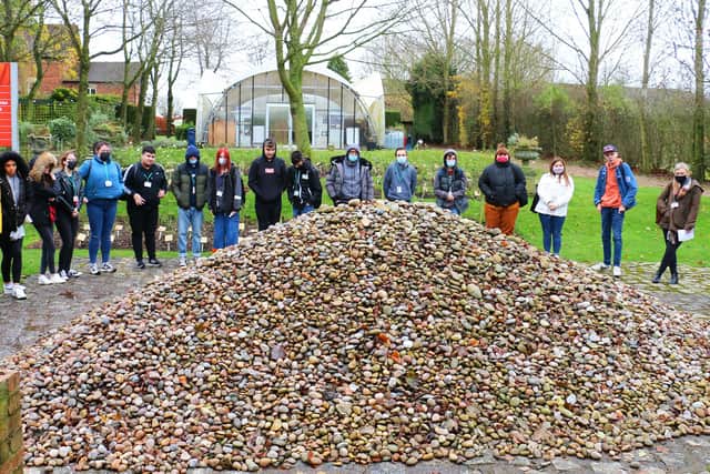 Creative arts students gathered around the stones dedicated to children of the Holocaust