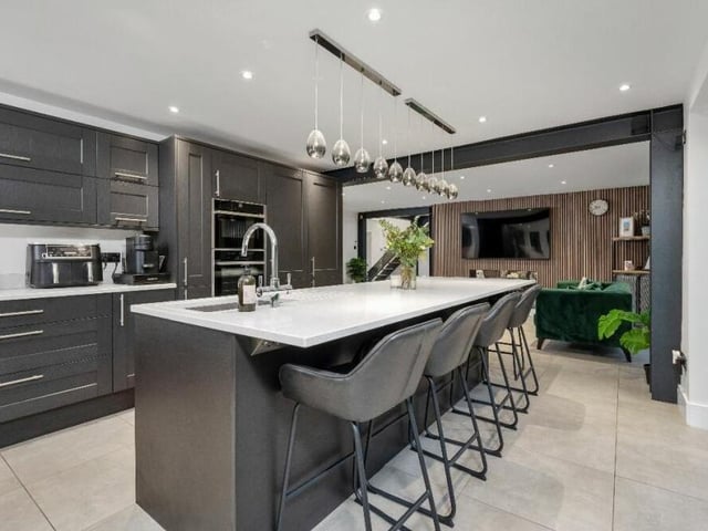 The contemporary kitchen can only be described as exceptional. A three-metre central island incorporates matching granite work surfaces, an inset Franke sink and a four-way mixer tap with a filtered and boiling water function.
