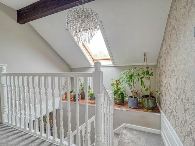 The staircase in the hallway leads to this landing, which gives access to all the first-floor rooms. Note another beautiful chandelier light.