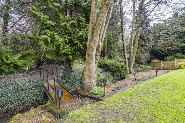 Beyond the rear garden is this footbridge, over a stream, that leads to enchanting woodland. It invites exploration with the kids, and connects the property to nature.