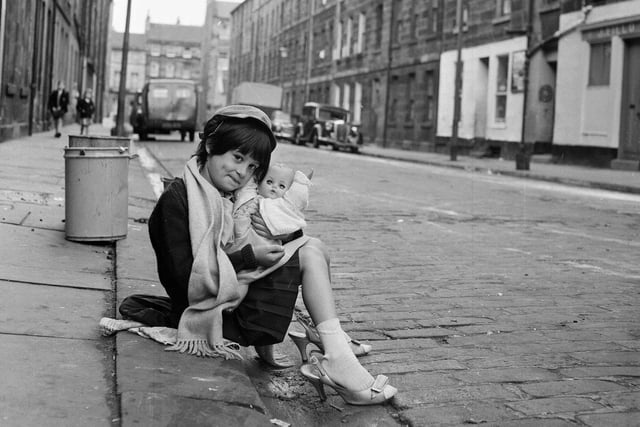 Diane Molloy and her doll dressing-up in Mummy's shoes in Jamaica Street Edinburgh, 1964. This little girl is now Diana Tookey.