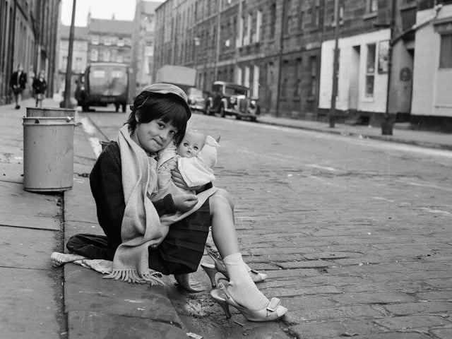 Diane Molloy and her doll dressing-up in Mummy's shoes in Jamaica Street Edinburgh, 1964. This little girl is now Diana Tookey.