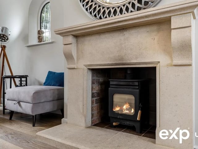 A log burner with a stone surround creates a sophisticated focal touch