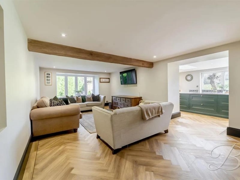 A versatile dining and living area finished with elegant herringbone flooring and central heating, creating a warm and welcoming environment. A charming log burner fireplace provides a cosy focal point, perfect for relaxing evenings.
