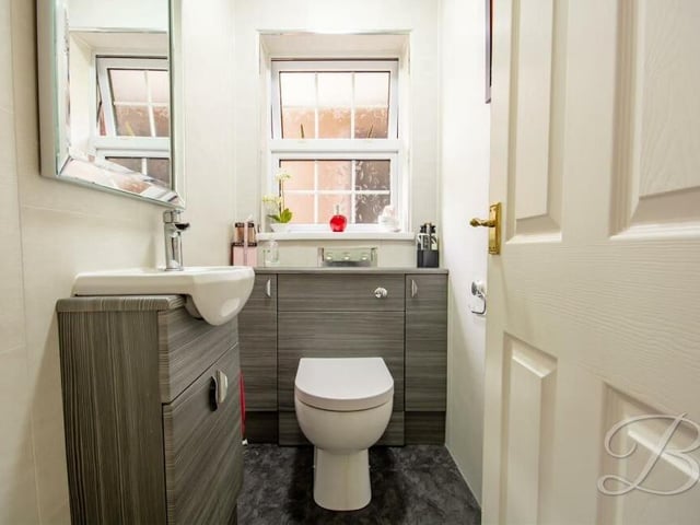 A downstairs toilet is always handy. This one contains a low-flush WC, integrated sink, cupboard and opaque window to the side of the house.
