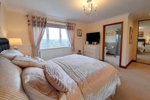 Here is the master bedroom, which features built-in, mirrored wardrobes and en suite facilities. The double-glazed window overlooks the back garden of the £499,950 property.