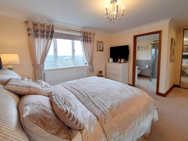 Here is the master bedroom, which features built-in, mirrored wardrobes and en suite facilities. The double-glazed window overlooks the back garden of the £499,950 property.