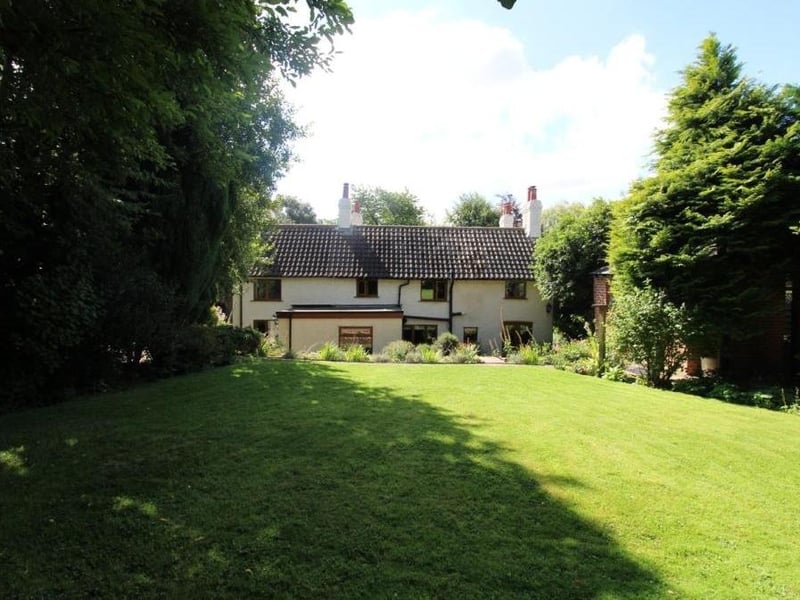 A view of the back of the £700,000-plus property, from one of its well-maintained, tree-lined lawns.