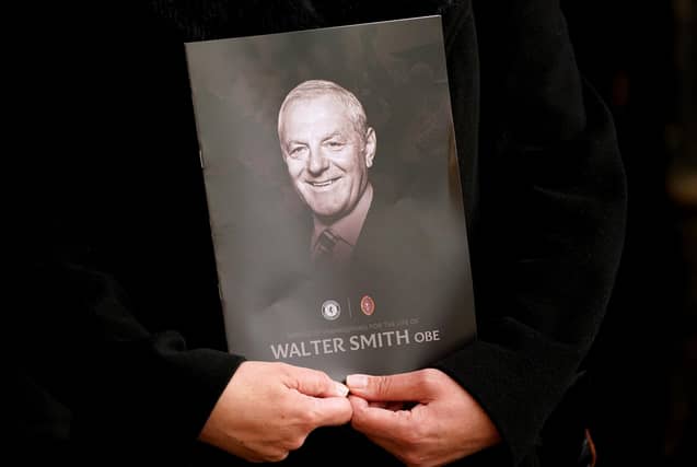 A person holds the order of service during Walter Smith's memorial service at Glasgow Cathedral.