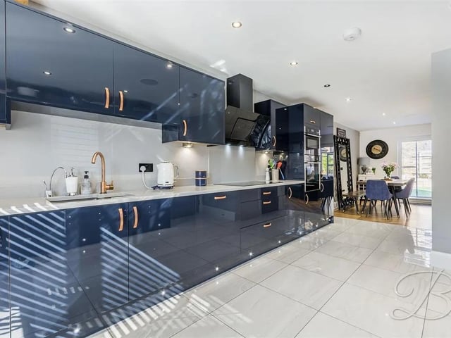 The kitchen is fitted with a sleek range of modern units and cabinets.