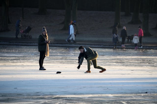 A person throws a stone on a frozen pond at Victoria Park in Glasgow. PA Photo. Picture date: Wednesday January 6, 2021. Forecasters predict that the cold spell affecting much of the UK is due to continue, with temperatures expected to remain slightly below average into next week. Photo credit should read: Andrew Milligan/PA Wire