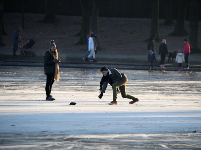 A person throws a stone on a frozen pond at Victoria Park in Glasgow. PA Photo. Picture date: Wednesday January 6, 2021. Forecasters predict that the cold spell affecting much of the UK is due to continue, with temperatures expected to remain slightly below average into next week. Photo credit should read: Andrew Milligan/PA Wire