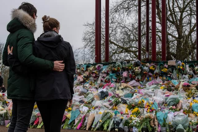 A couple look at floral tributes left at Clapham Common bandstand in memory of Sarah Everard, who was kidnapped, raped and murdered earlier this year. (PHOTO BY: Chris J.Ratcliffe/Getty Images)