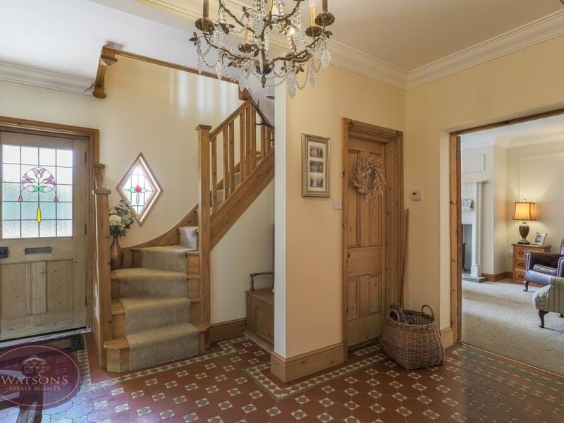 As we prepare to go upstairs, let's pass through the smart entrance hallway, with its Minton tiled flooring. It includes a cupboard housing a combination boiler and hot-water tank.