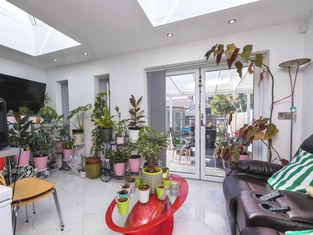 The cosy living area of the open-plan hub. Two lantern skylights ensure there is plenty of natural light, while the bi-folding doors open out to the garden.