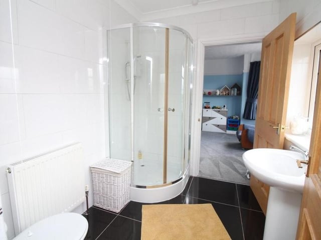 Bedrooms number two and four have 'Jack And Jill' access to this en suite bathroom, with its three-piece suite in white. It consists of a corner shower cubicle with mains-fed shower, pedestal sink unit and WC