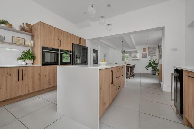 Moving into the bright and contemporary, open-plan dining kitchen now. It is fitted with a range of oak-style wall-cupboards, base units and drawers, complemented by quartz worktops.