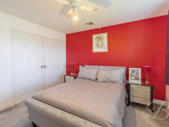 This second image of the master bedroom shows its large fitted wardrobes. No need to throw away any of your clothes when you move in here! The floor is carpeted.