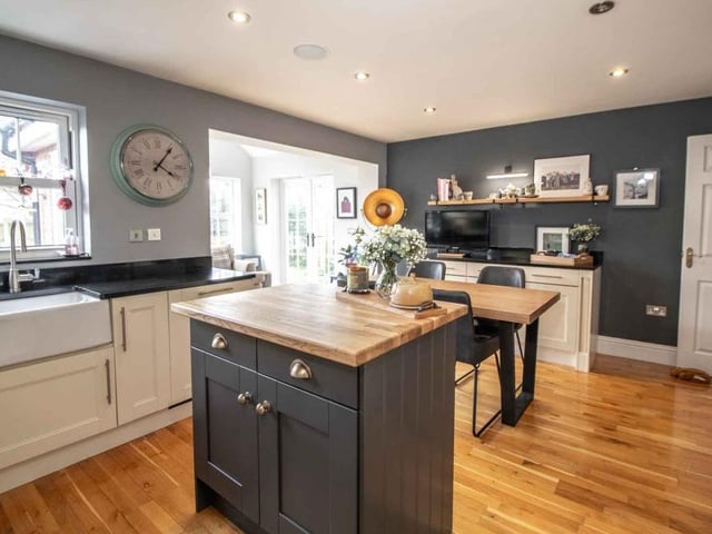 Storage cupboards abound in the attractive kitchen/breakfast room, which is also fitted with a range of wall and floor-mounted units in an ivory shaker style.