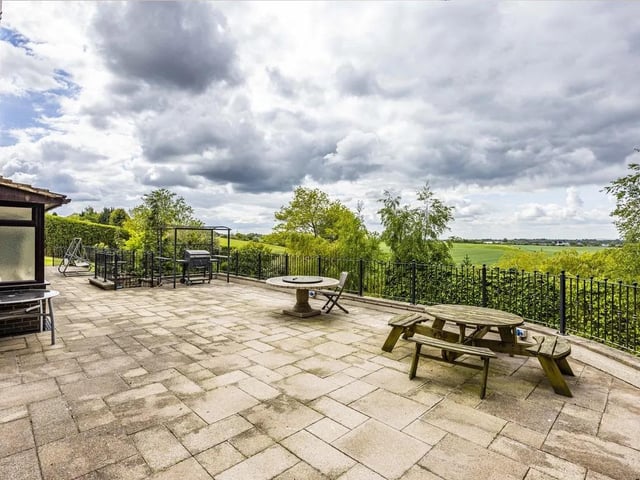 An expansive rear terrace spans the back of the property, providing the perfect place to entertain, unwind and soak in the peaceful setting