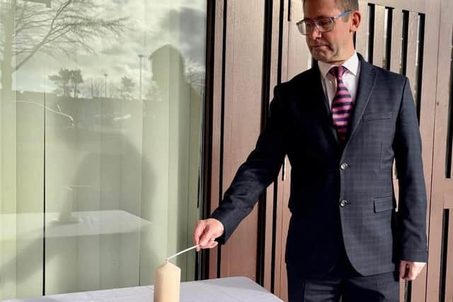 Mayor Andy Abrahams lights the candle.