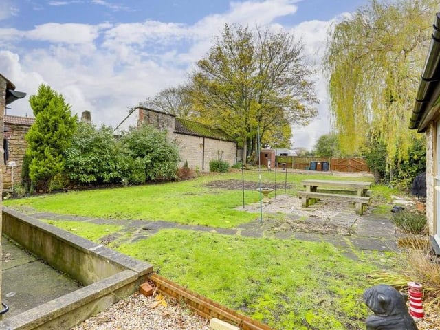 A view of the enclosed garden and patio from the rear of the property.