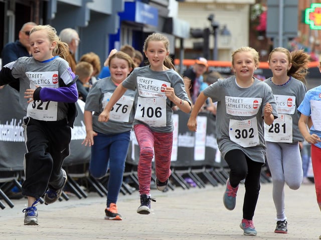 Runners make the 60m dash for the finish line.